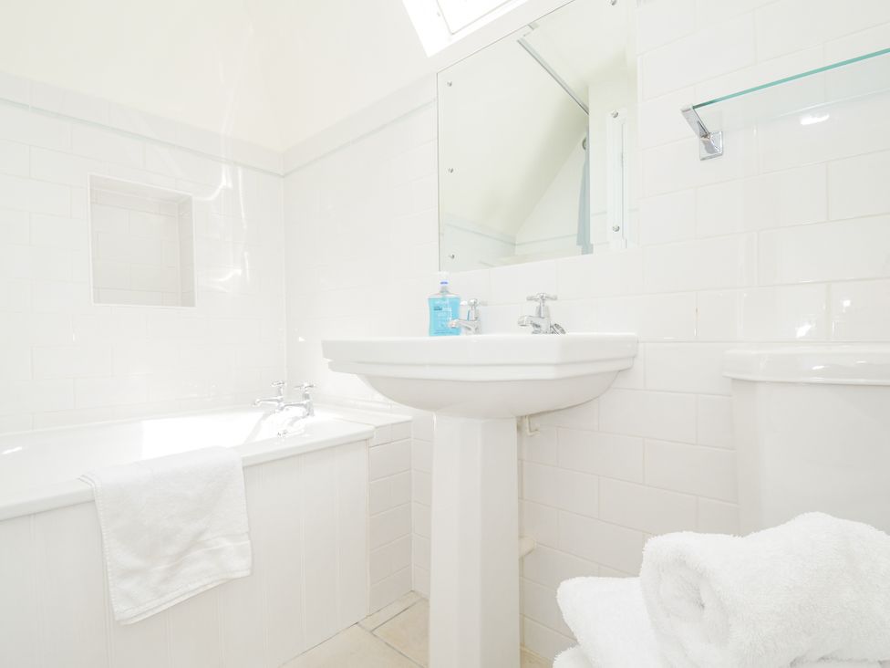 A bathroom with a bath tub and sink at Bodare 8 in Daymer Bay