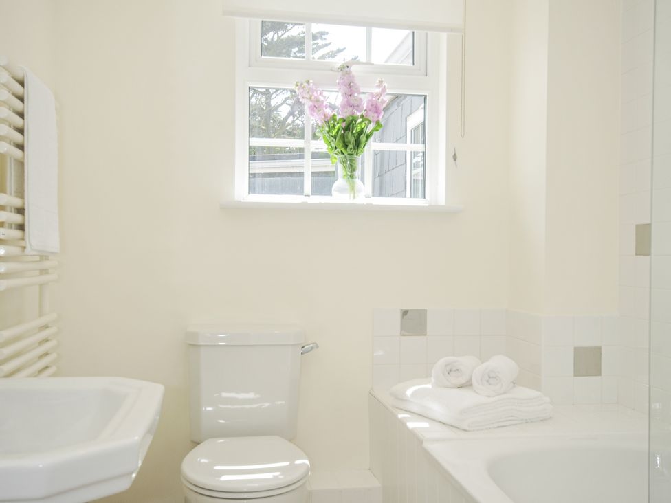 A bathroom with a bathtub and toilet at Bodare 8 in Daymer Bay
