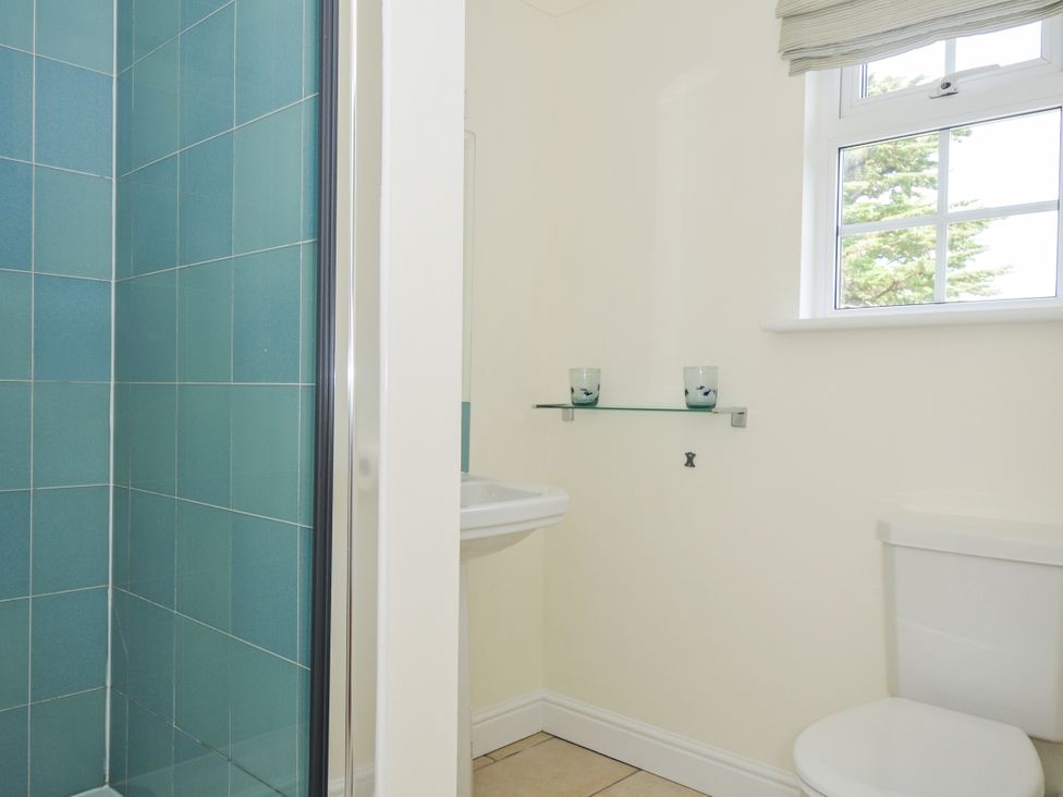 A bathroom with a toilet, sink and shower at Bodare 8 Daymer Bay