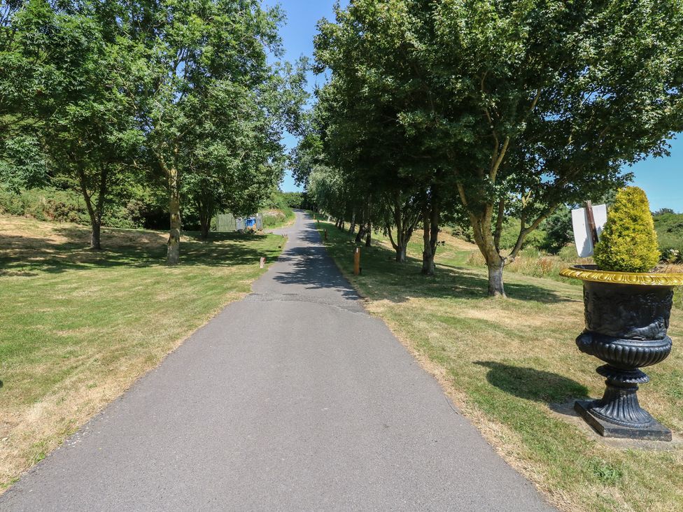 A pathway lined with trees and a decorative planter at Finnbars Lodge in Richmond