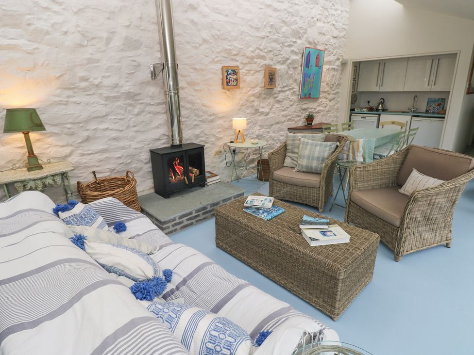 A living room with a fireplace and sofa at Curlew House in Cosheston