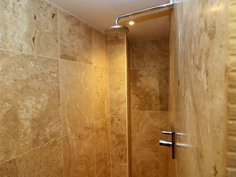 A shower with tiles in a bathroom at Curlew House in Cosheston