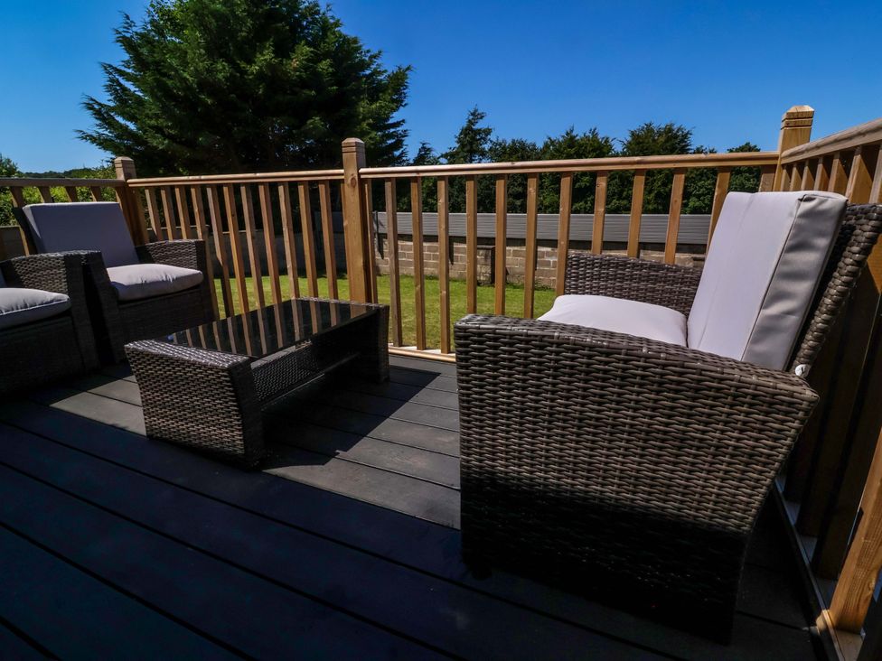 A deck with outdoor chairs and a table at West View near Hatherleigh