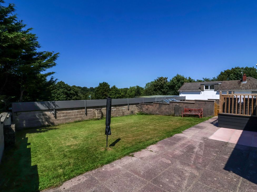 A garden with grass and a bench at West View in Northlew near Hatherleigh