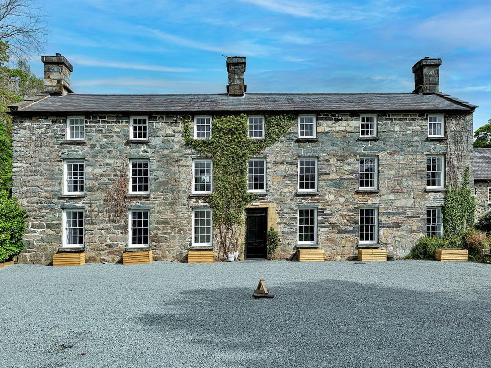 A stone building with large windows and planters at Snowdonia Manor in Dolgellau
