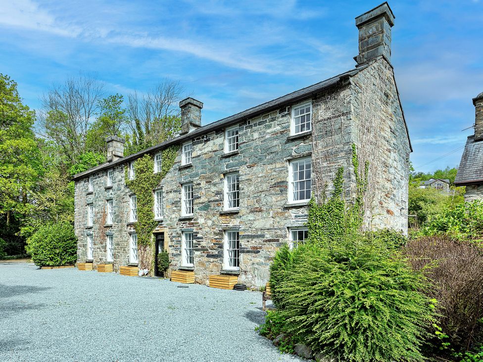 A stone building with windows and landscaping at Snowdonia Manor in Dolgellau