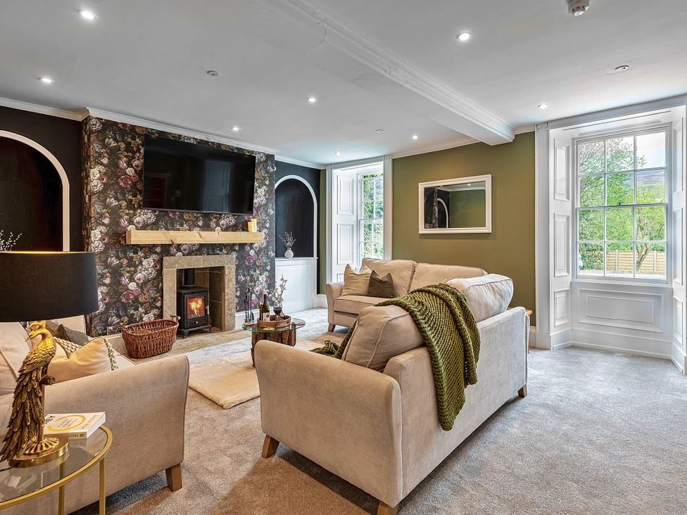 A living room with a fireplace and television at Snowdonia Manor in Dolgellau