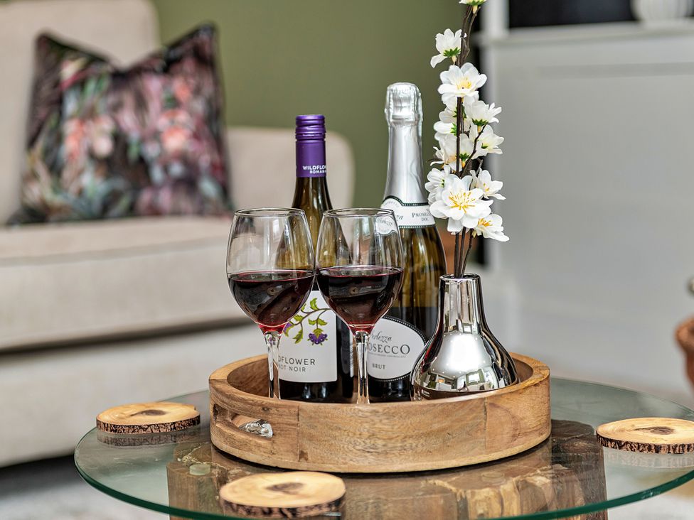 A living room with wine glasses and bottles on a wooden tray at Snowdonia Manor in Dolgellau
