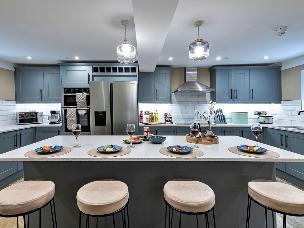 A kitchen with an island and bar stools at Snowdonia Manor in Dolgellau