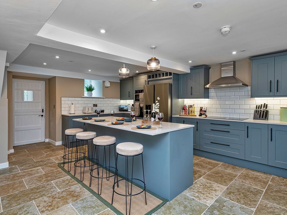 A kitchen with a bar counter and stools at Snowdonia Manor in Dolgellau