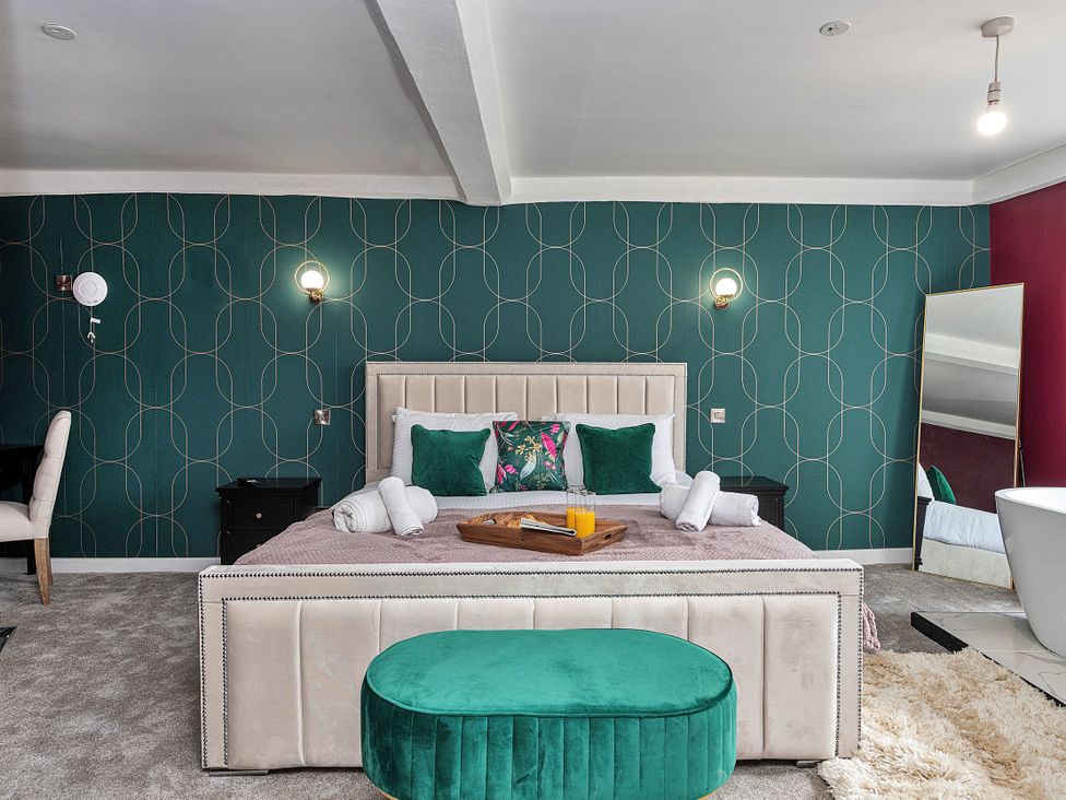 A bedroom with a bed and a mirror at Snowdonia Manor in Dolgellau