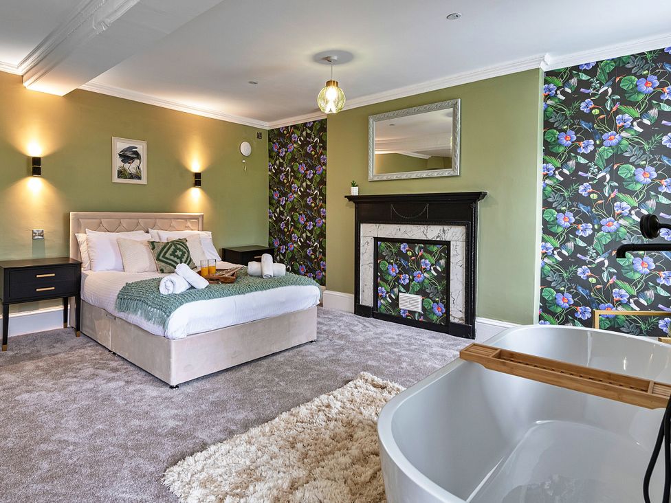 A bedroom with a bed and fireplace at Snowdonia Manor in Dolgellau