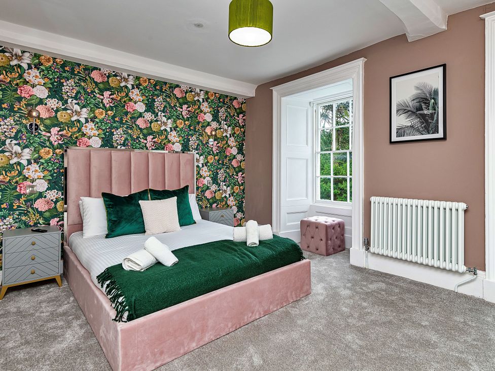 A bedroom with a bed and nightstand at Snowdonia Manor in Dolgellau