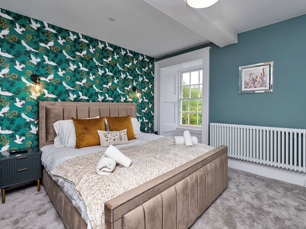 A bedroom with a bed and nightstand at Snowdonia Manor in Dolgellau