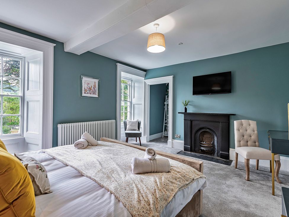 A bedroom with a bed and windows at Snowdonia Manor in Dolgellau