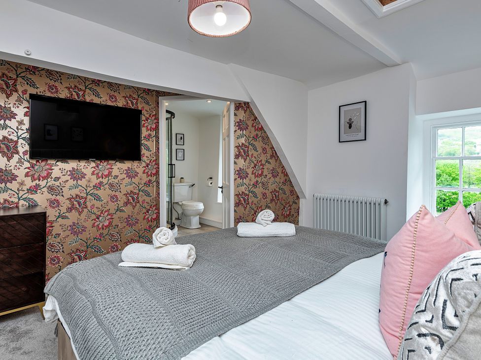 A bedroom with a bed and television at Snowdonia Manor in Dolgellau