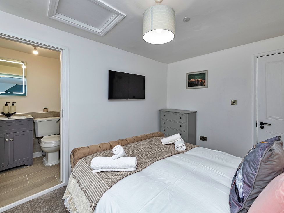 A bedroom with a bed and an attached bathroom at Snowdonia Manor in Dolgellau