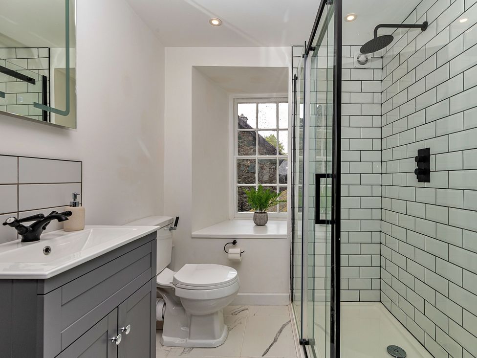 A bathroom with a shower, sink, and toilet at Snowdonia Manor in Dolgellau