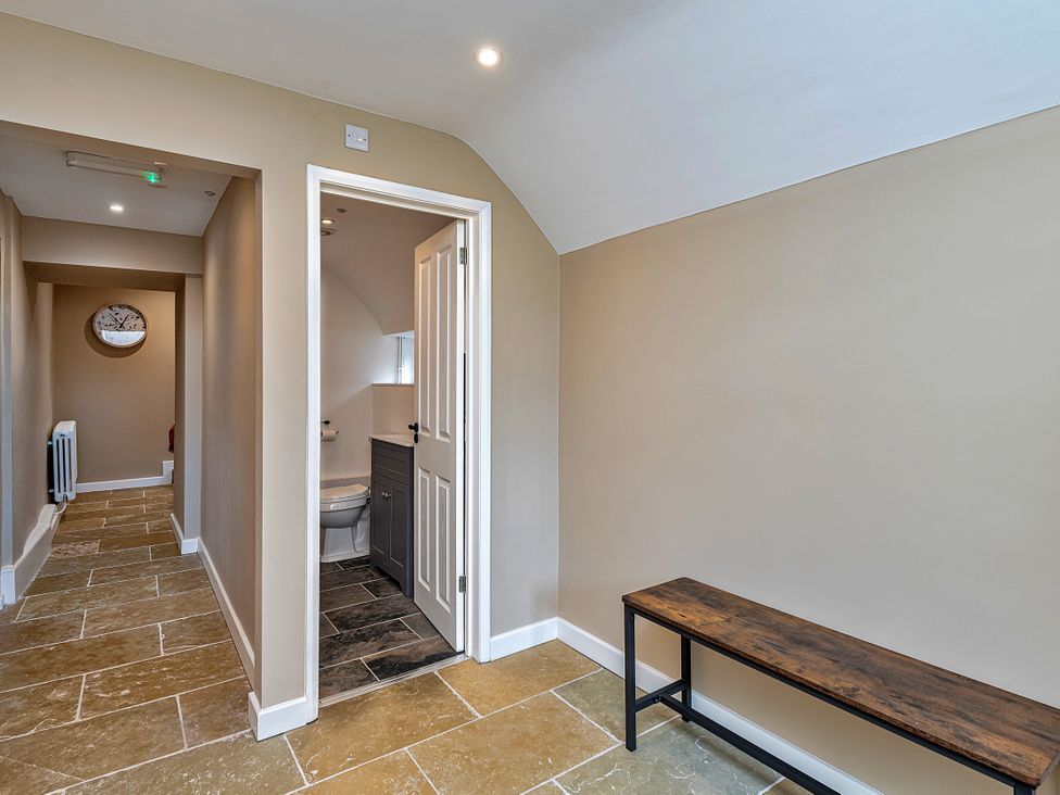 A hallway with a bench and door leading to a bathroom at Snowdonia Manor in Dolgellau