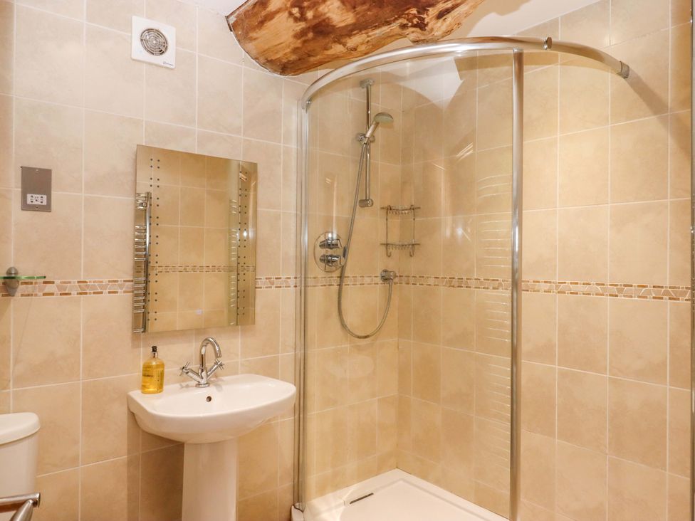 A bathroom with a shower, sink, and mirror at Swallows Reach Halwell