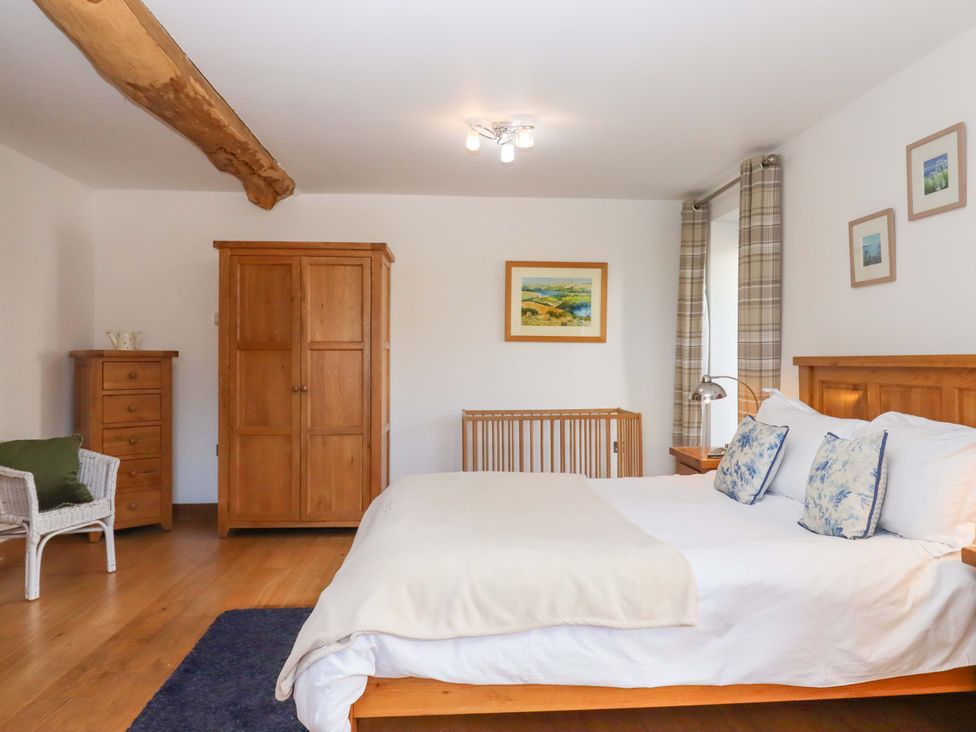 A bedroom with a bed and wardrobe at Swallows Reach Halwell