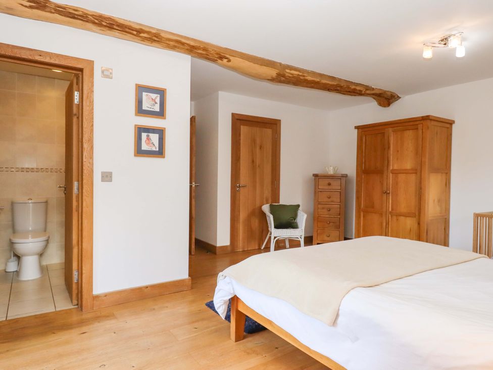 A bedroom with a bed and wardrobe at Swallows Reach Halwell