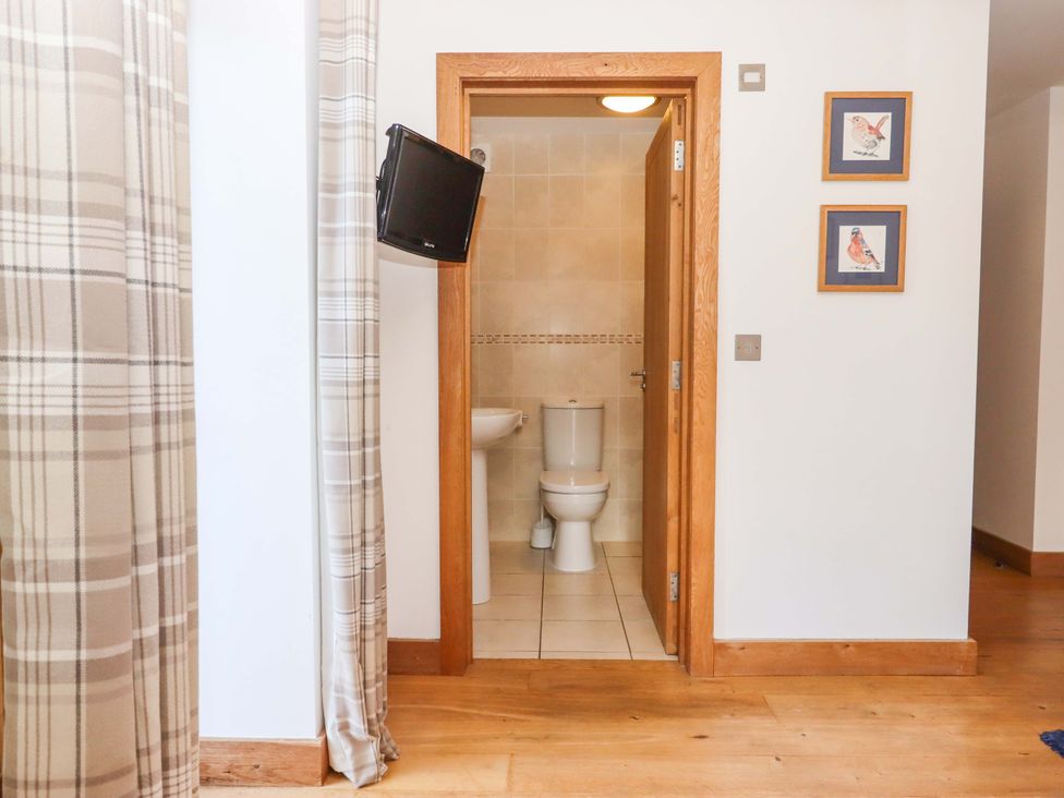 A bathroom with a toilet and sink visible at Swallows Reach Halwell