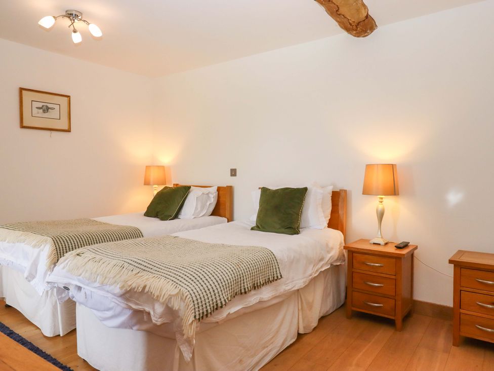 A bedroom with twin beds and nightstands at Swallows Reach in Halwell