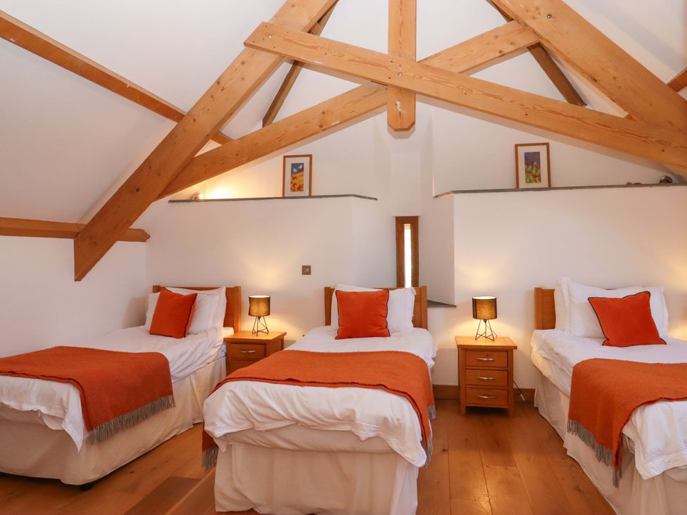 A bedroom with three beds at Swallows Reach Halwell