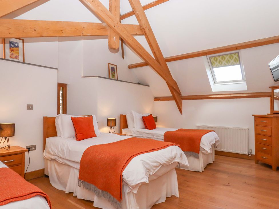 A bedroom with beds and a dresser at Swallows Reach Halwell