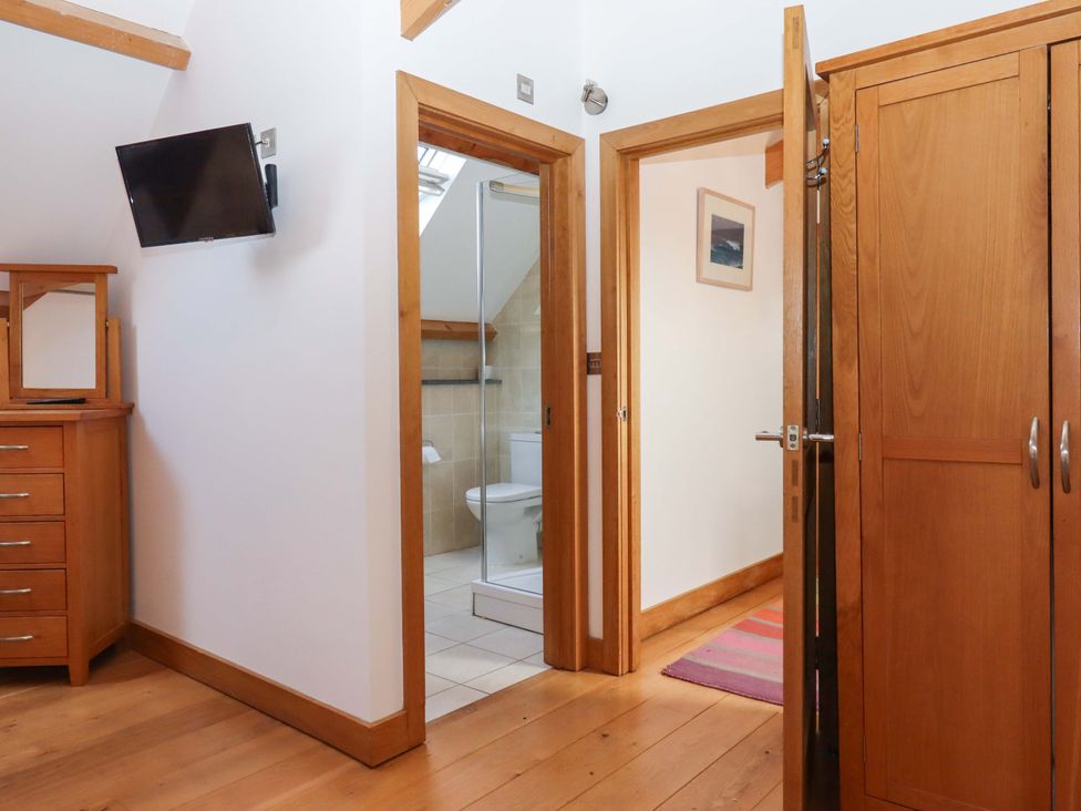 A bedroom with a dresser and television at Swallows Reach in Halwell