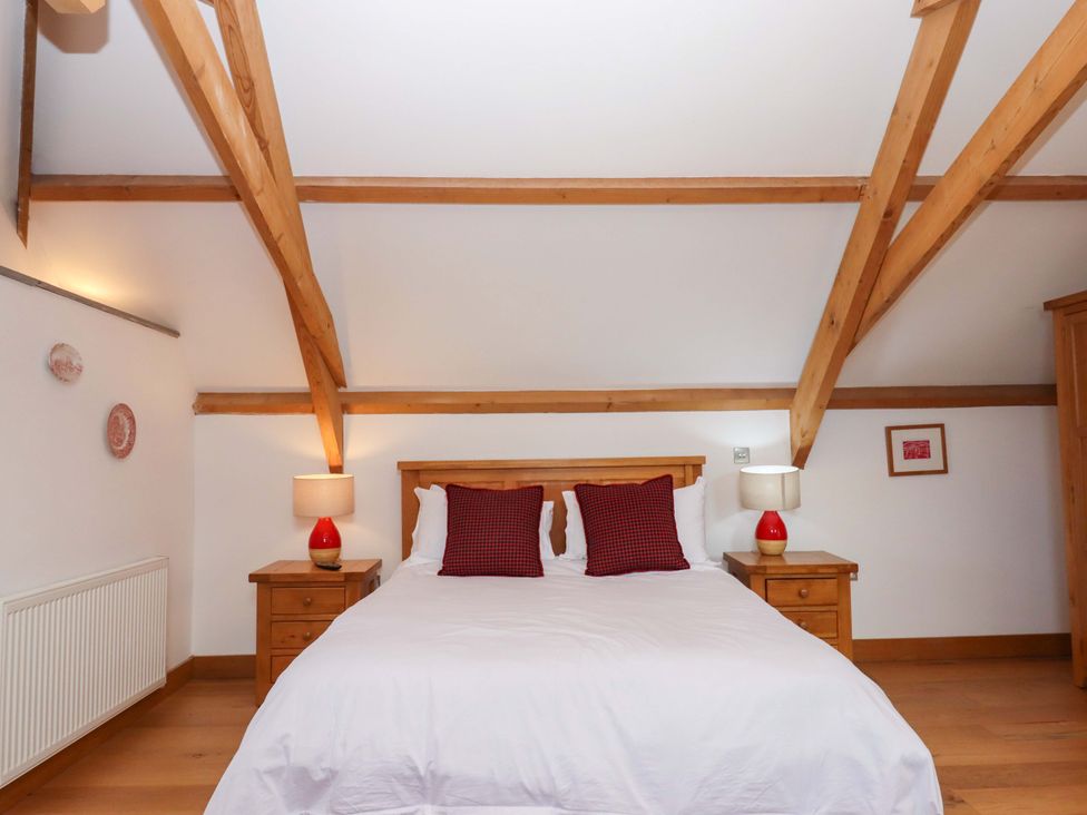 A bedroom with a bed and bedside tables at Swallows Reach Halwell