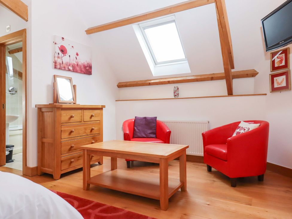 A living room with armchairs and a coffee table at Swallows Reach in Halwell