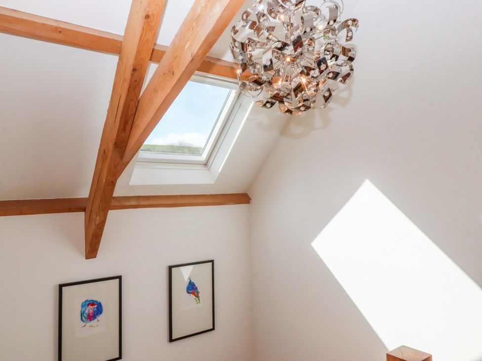 A room with a chandelier and paintings on walls at Swallows Reach Halwell