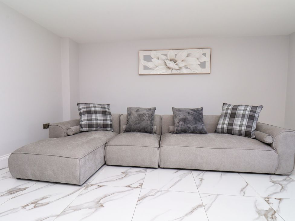 A living room with a grey sofa and cushions at Plot Four - Italian Terraced Garden Harpham near Nafferton