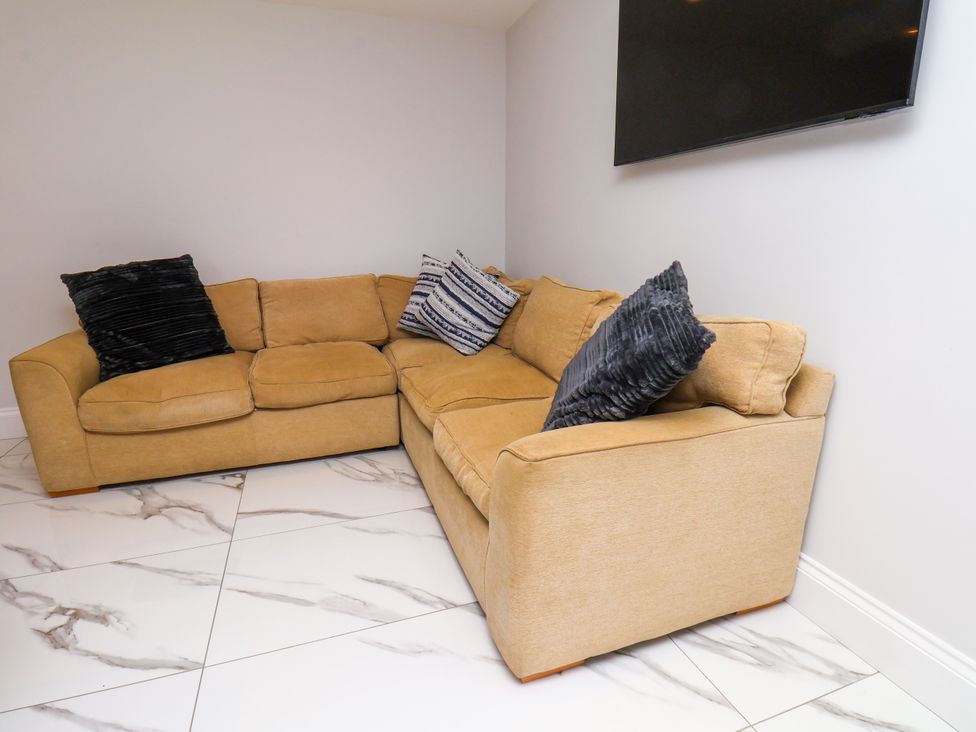 A living room with a corner sofa and a television at Plot Four - Italian Terraced Garden Harpham near Nafferton
