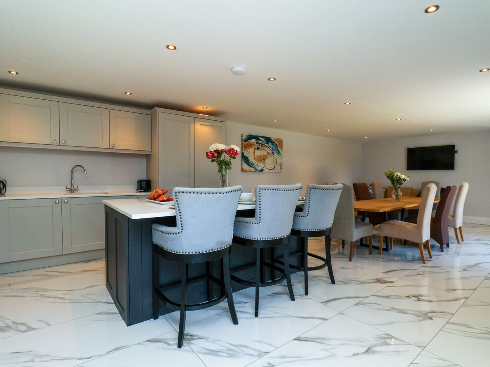 A kitchen with an island, bar stools and dining area at Plot Four - Italian Terraced Garden Harpham near Nafferton