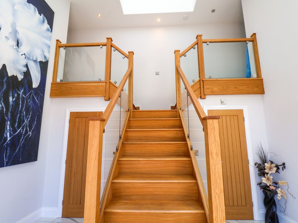 A staircase with a railing and artwork in a hallway at Plot Four - Italian Terraced Garden Harpham near Nafferton