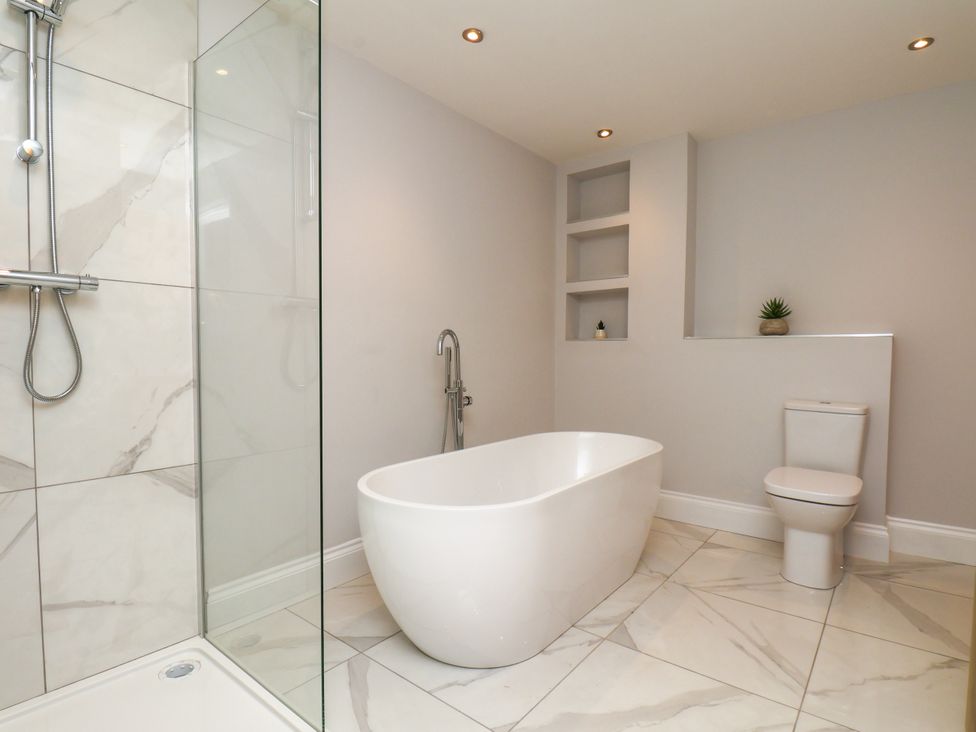 A bathroom with a bathtub, shower, and toilet at Plot Four - Italian Terraced Garden Harpham near Nafferton