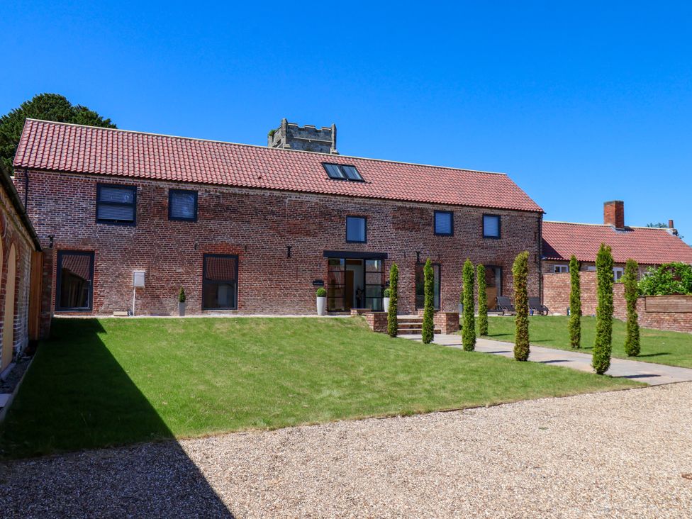 A brick building with windows and a garden at Plot Four - Italian Terraced Garden Harpham near Nafferton