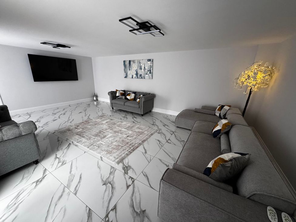A living room with a sofa and television at Courtenay House in Harpham near Nafferton