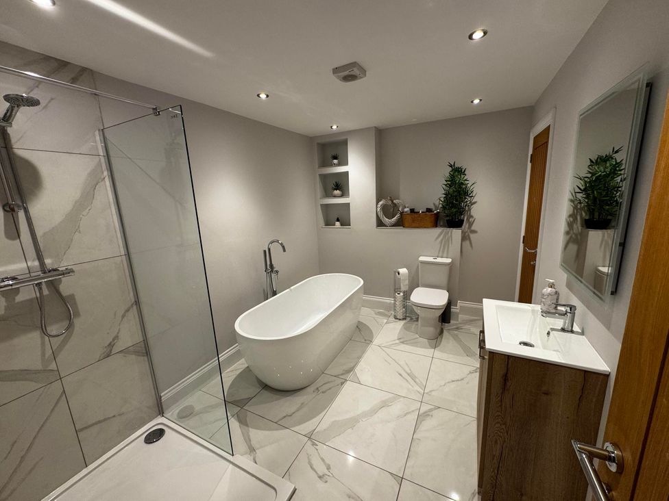 A bathroom with a bathtub and shower at Courtenay House Harpham near Nafferton