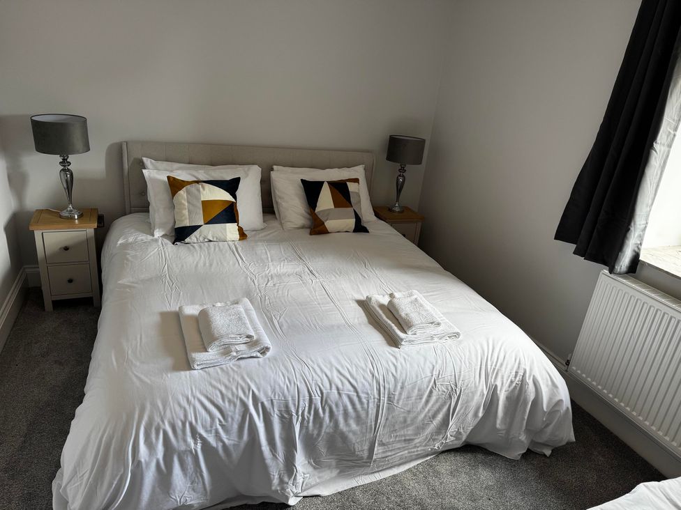 A bedroom with a bed and bedside table at Courtenay House in Harpham near Nafferton