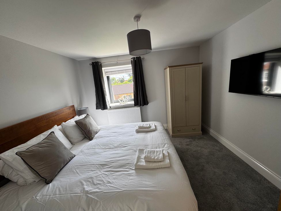 A bedroom with a double bed and wardrobe at Courtenay House Harpham near Nafferton