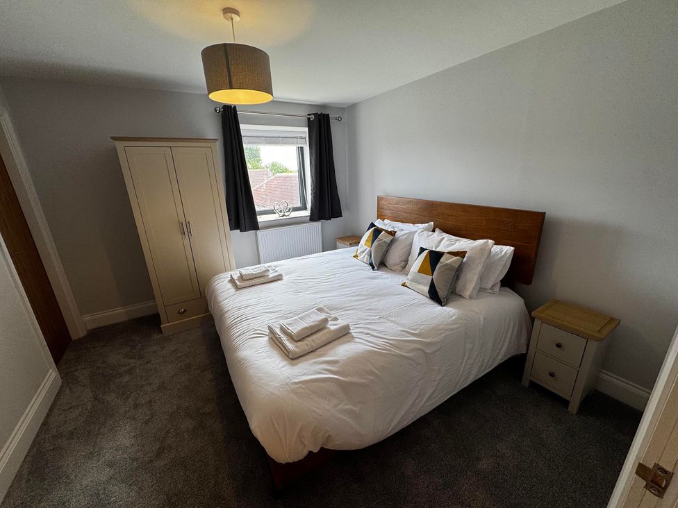 A bedroom with a double bed and wardrobe at Courtenay House Harpham near Nafferton
