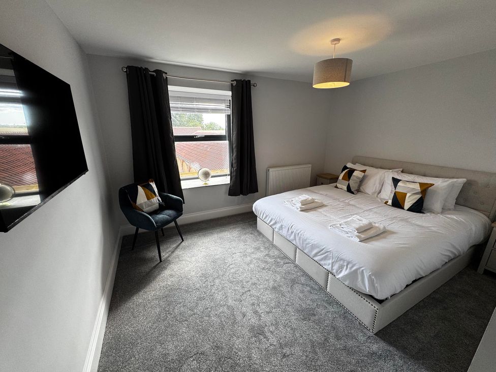 A bedroom with a bed and television at Courtenay House near Harpham