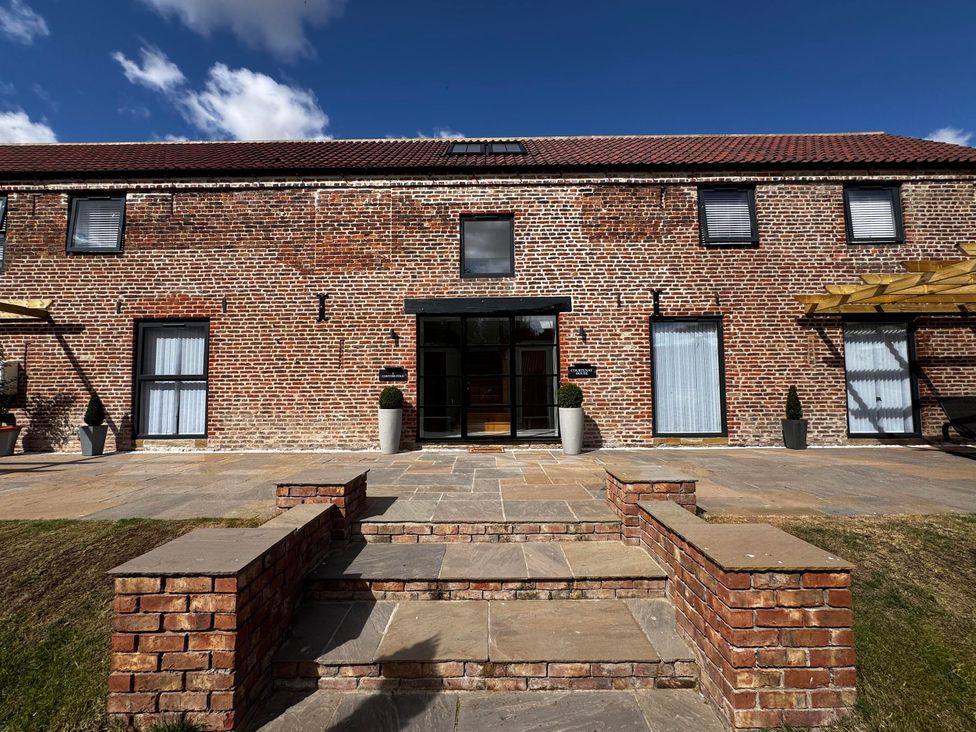 An exterior view of a brick house with steps at Courtenay House Harpham near Nafferton