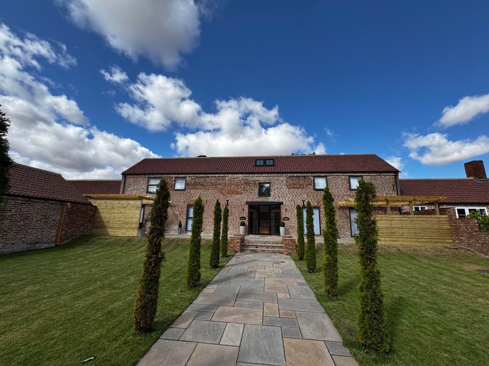 A house with a pathway and garden at Courtenay House Harpham near Nafferton