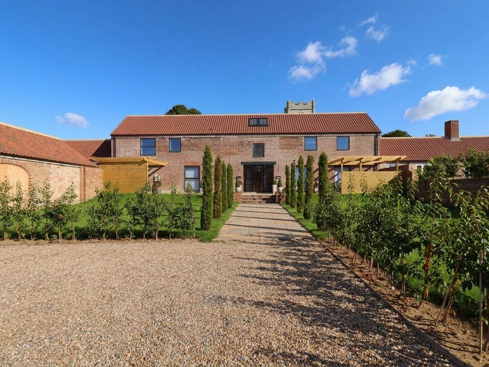 An outdoor view of a house with a pathway and garden at Courtenay House Harpham near Nafferton