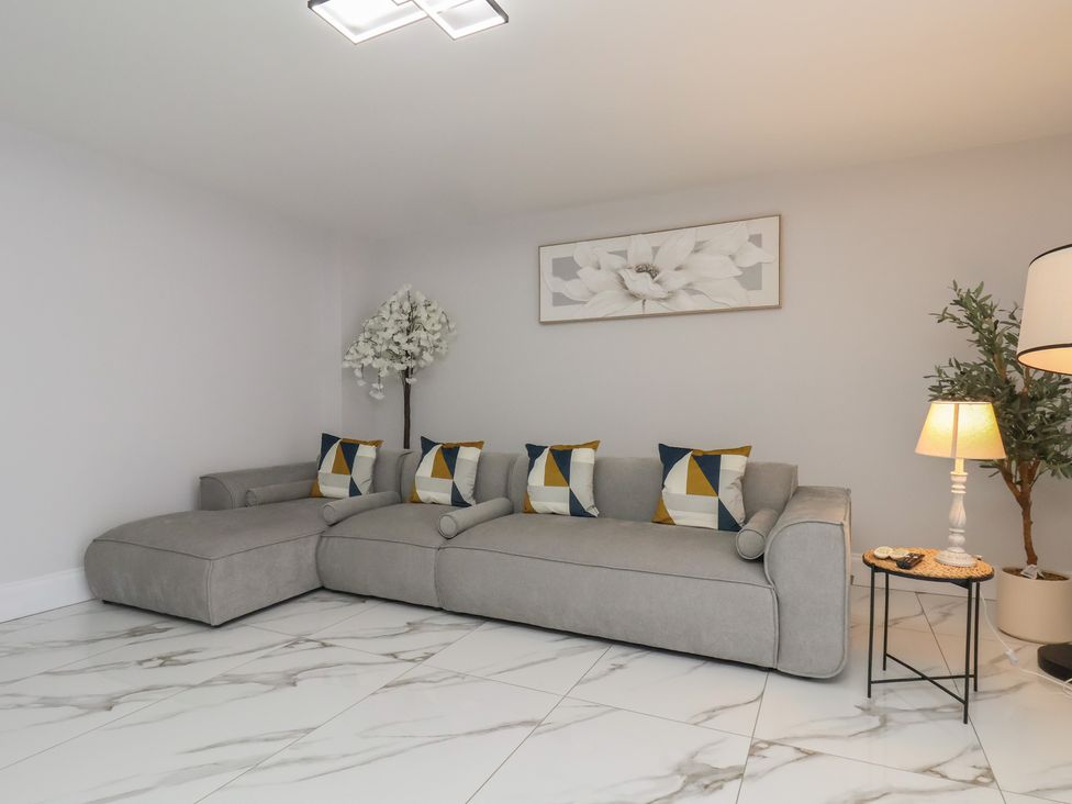 A living room with a sofa and side table at Courtenay House in Harpham near Nafferton